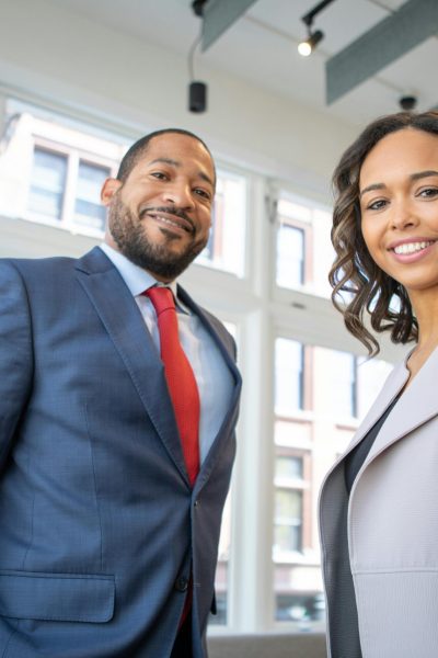 Business professionals smiling in a modern Detroit office setting.
